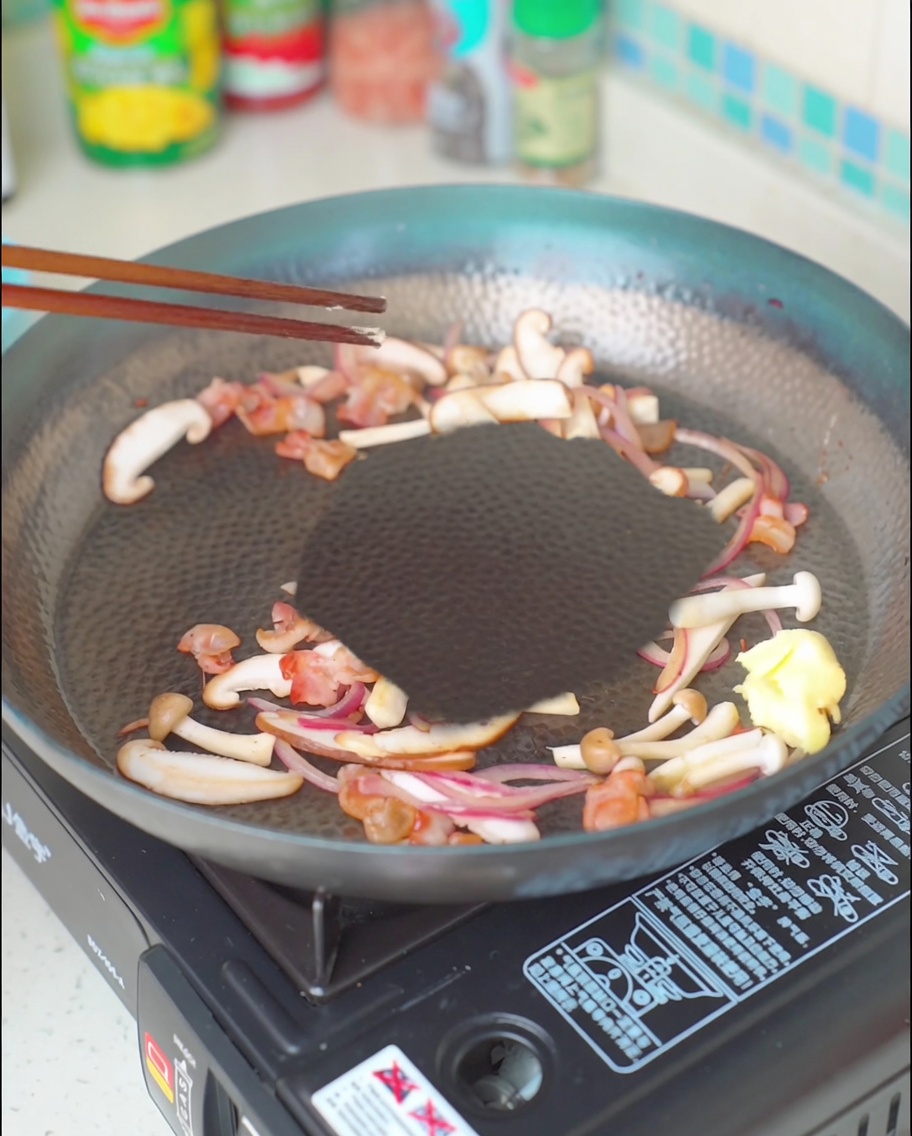 Un pezzo di burro che si scioglie nel mix di bacon, funghi e cipolla.