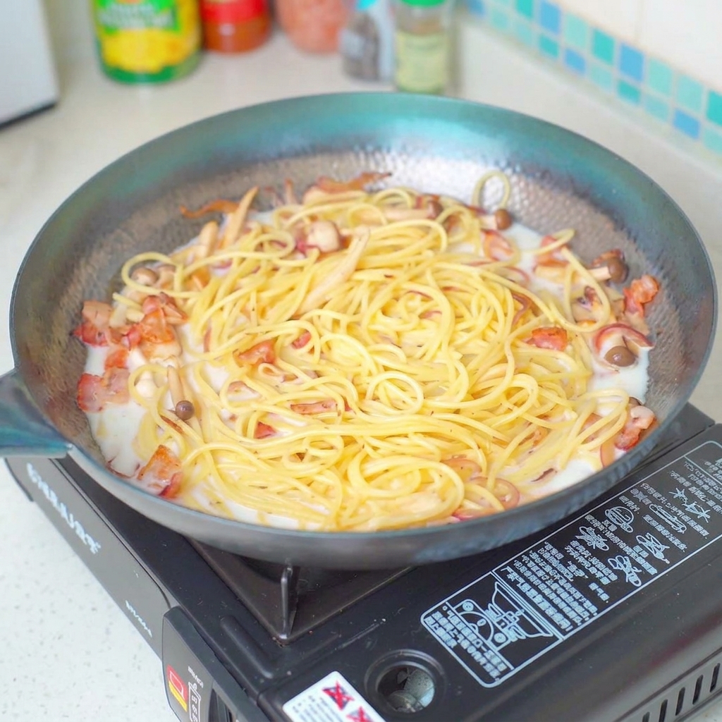 Condimento del piatto di pasta con sale mentre sobbolle nella padella.