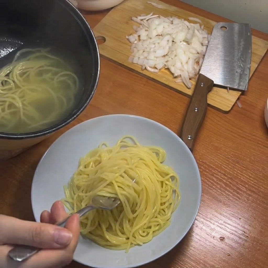 Spaghetti cotti sollevati dalla pentola con le bacchette.