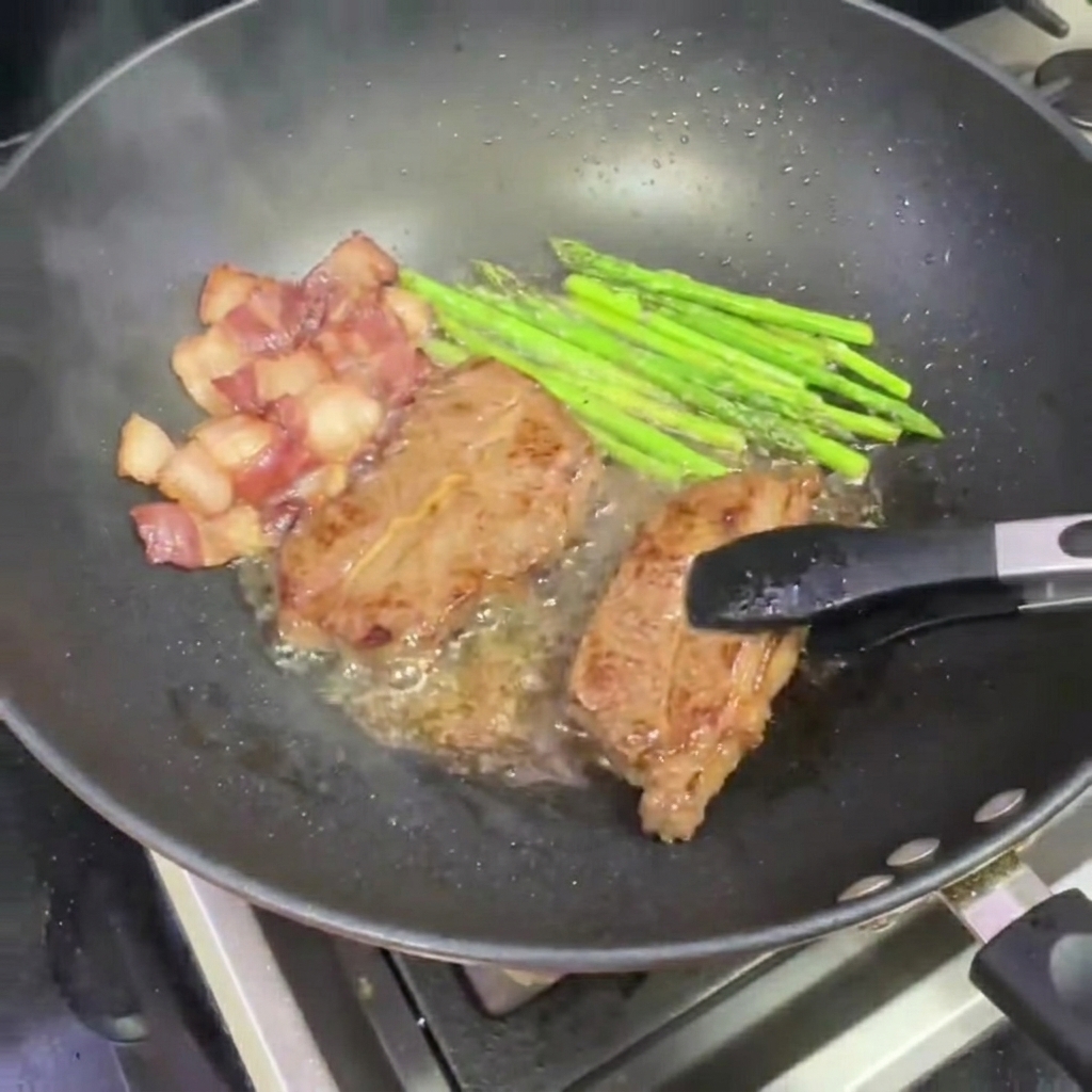 Pinze che rimuovono un pezzo di bistecca scottata dal wok.