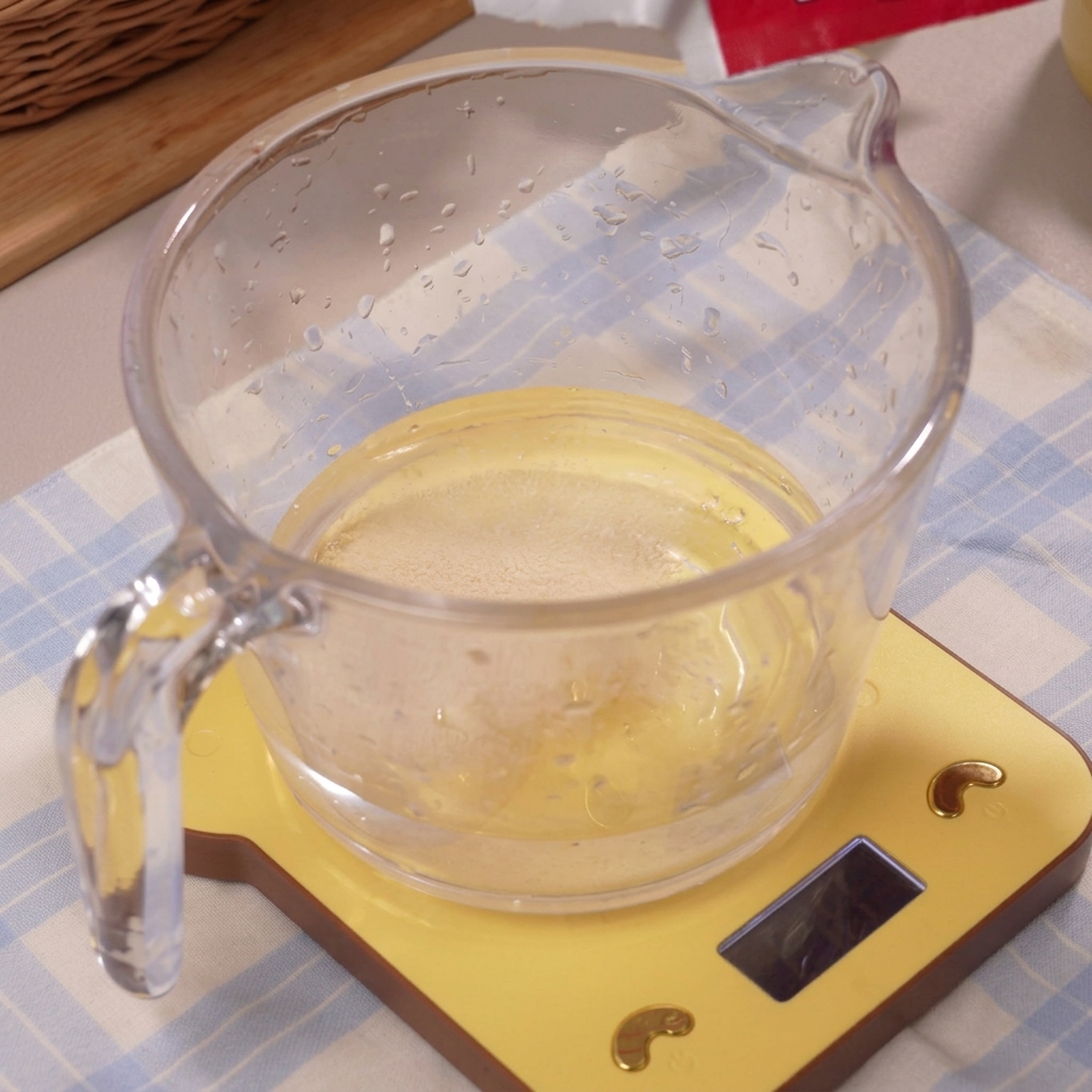 Il lievito che si scioglie nellacqua ghiacciata dentro un misurino.