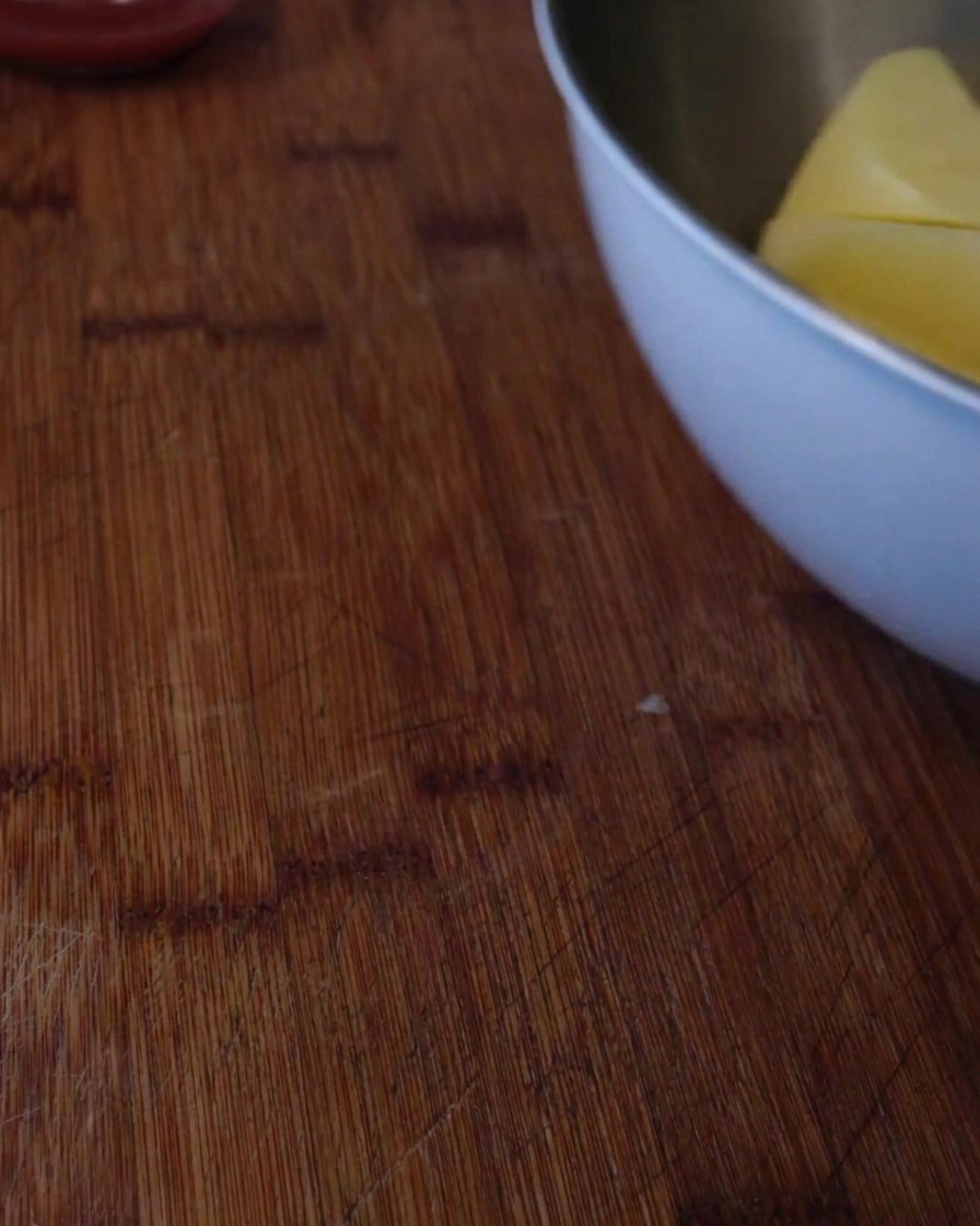 Un primo piano di cubetti di patate che bollono in una pentola capiente dacqua sul fornello.