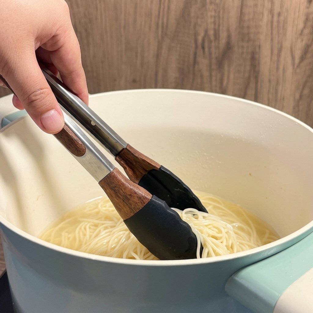 Noodle secchi per ramen immersi in acqua bollente dentro una pentola bianca.