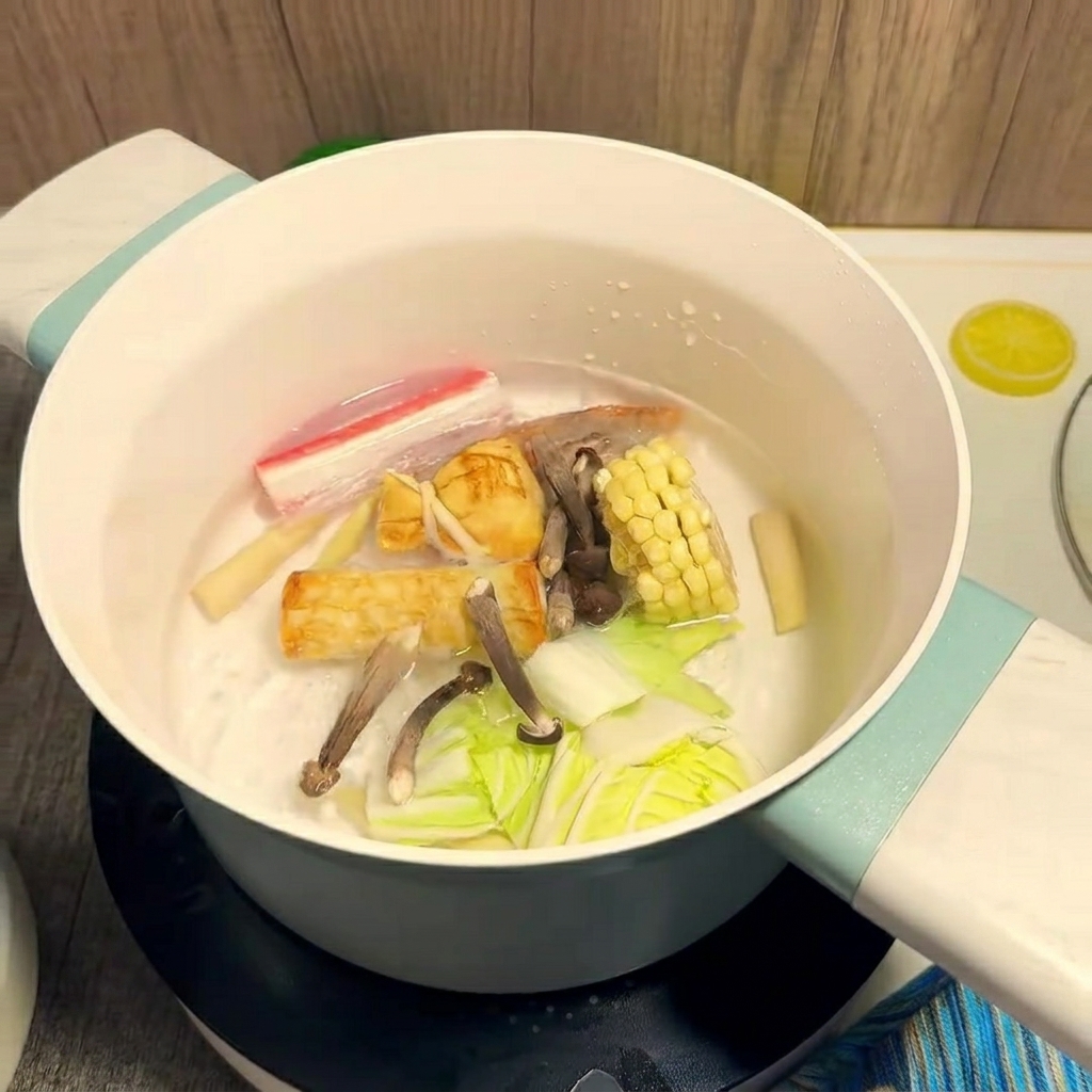Ingredienti colorati come mais e gamberi che cuociono in una pentola di acqua bollente.