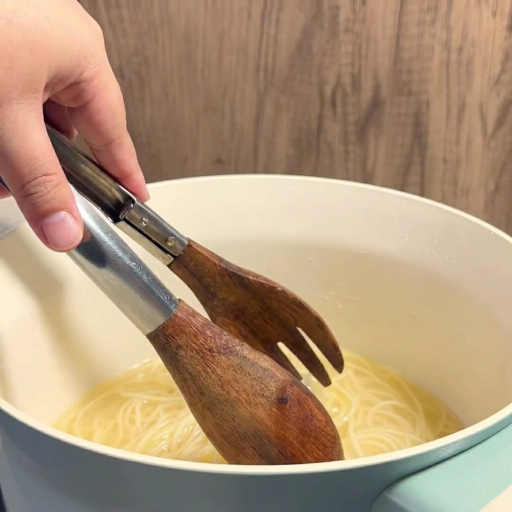 Brodo di mais al burro caldo e giallo versato con un mestolo in un bicchiere trasparente.