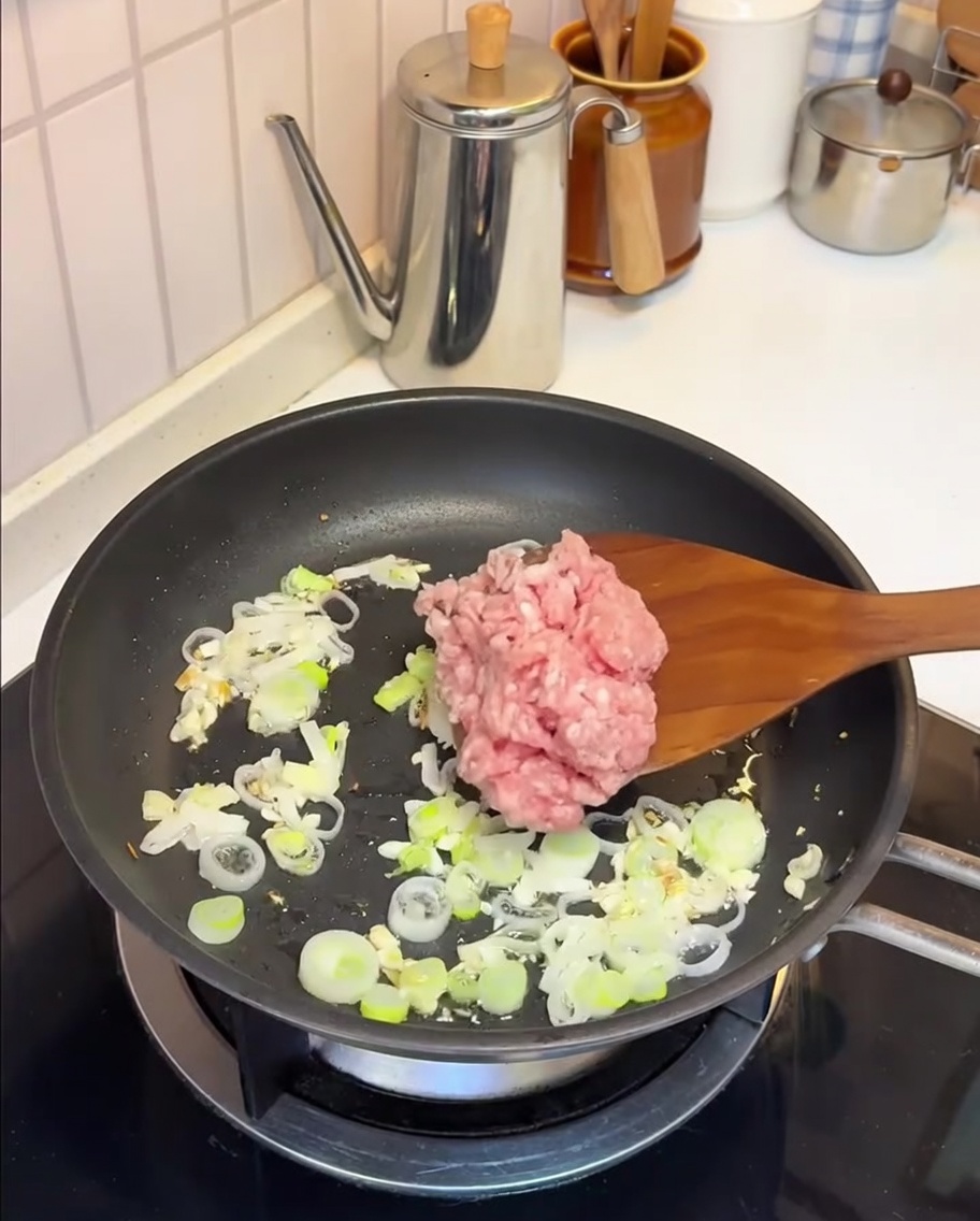 Macinato di maiale saltato in padella con aglio e cipollotto.