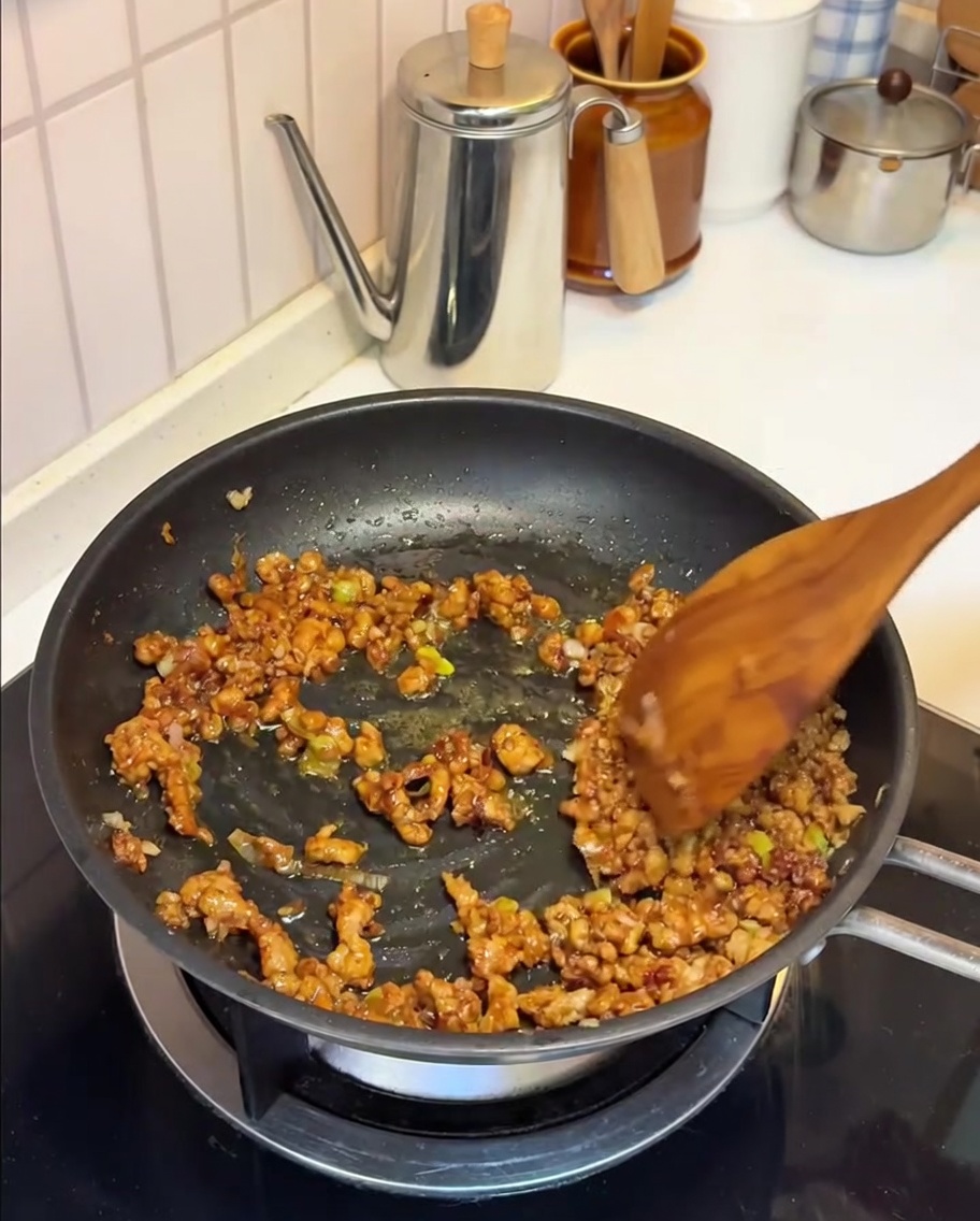 Latte di soia versato nella padella con il composto di maiale e miso.