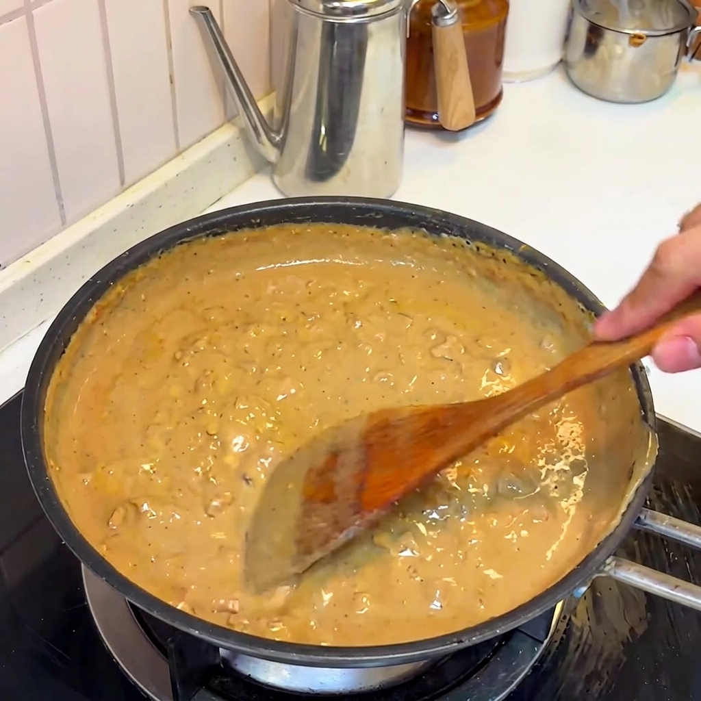 La salsa ricca di miso e maiale che sobbolle e si addensa in padella.