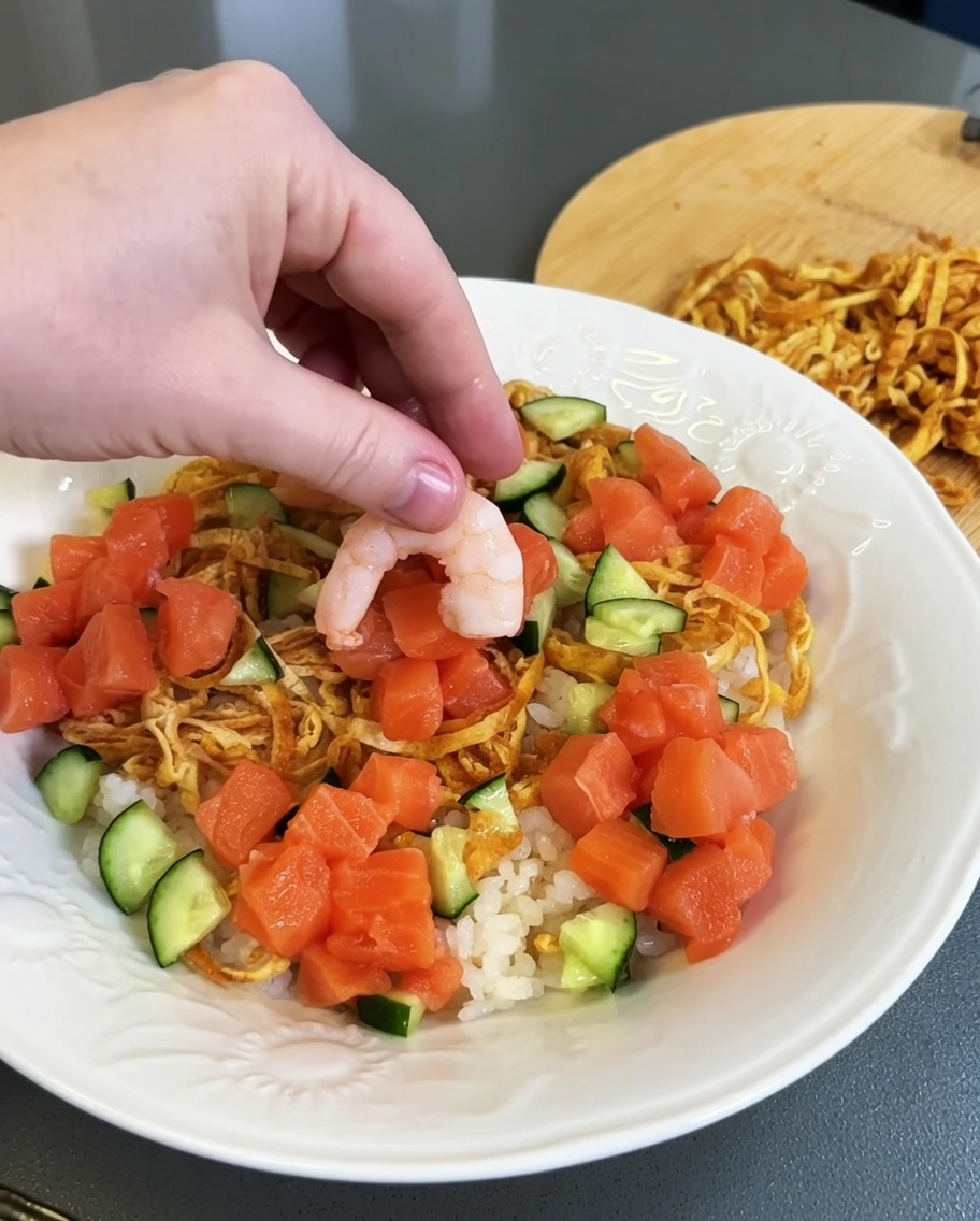 Grappoli di salmone crudo tagliato a cubetti posizionati sul riso.