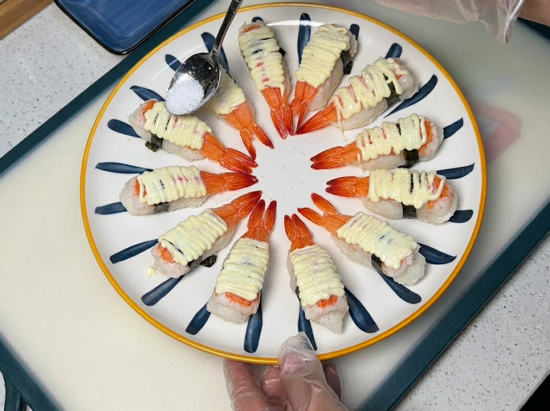 Un cucchiaio che sparge zucchero sopra il sushi alla maionese.
