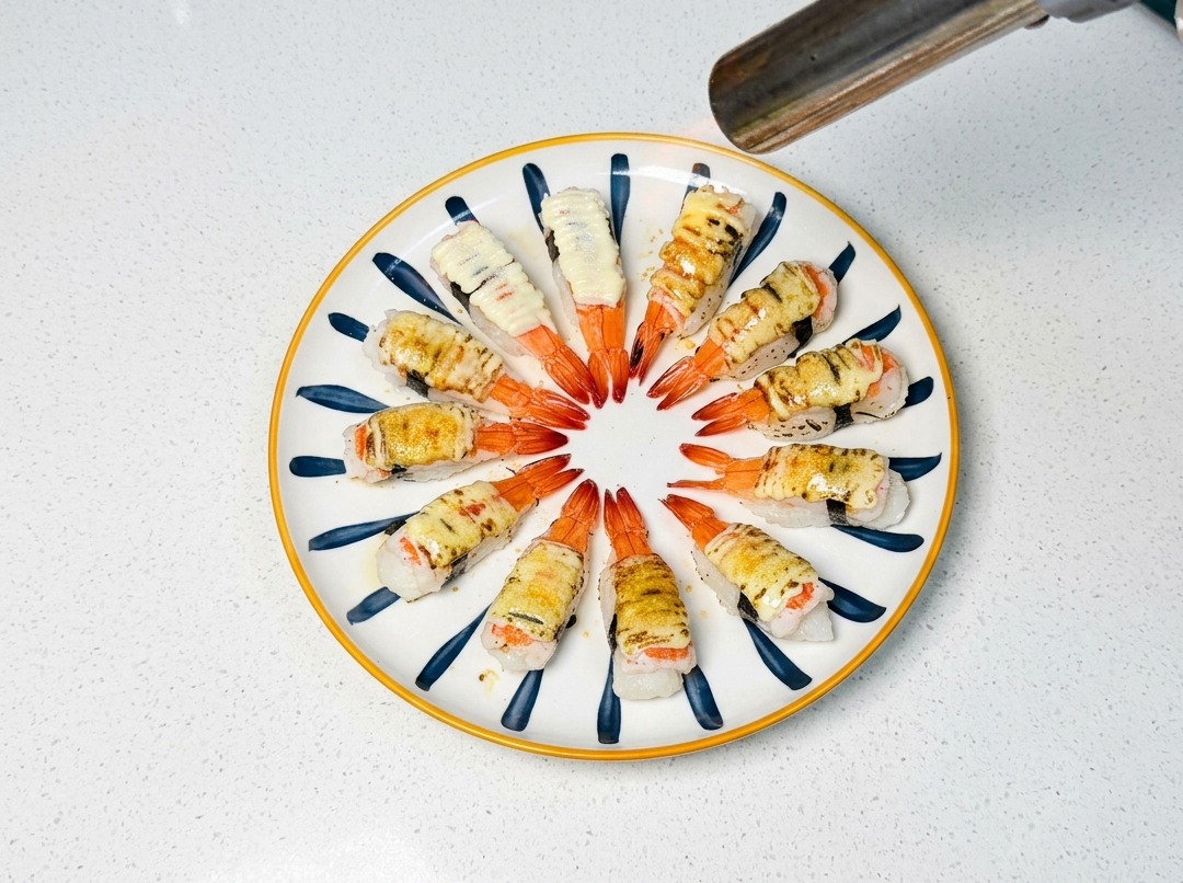 Un cannello da cucina che dora la maionese e lo zucchero sul sushi.