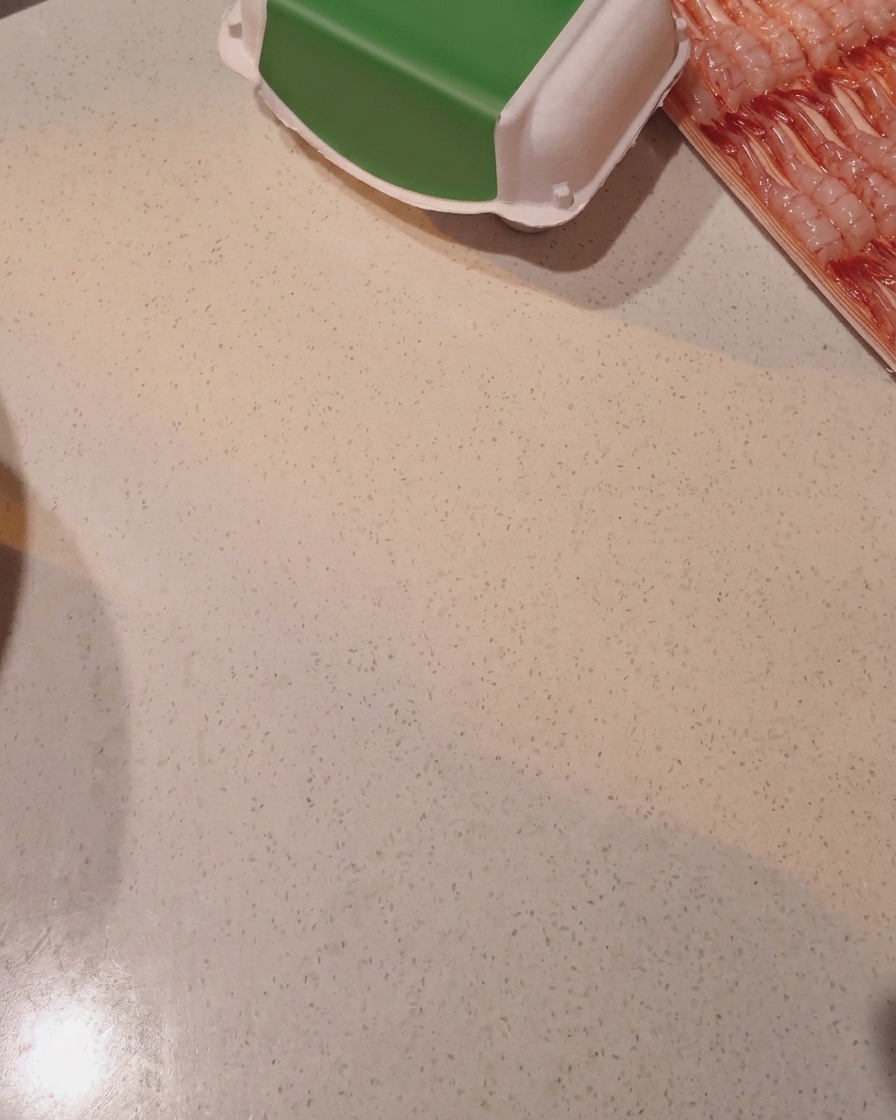 Riso che viene lavato nella pentola del cuociriso sotto il getto dacqua.