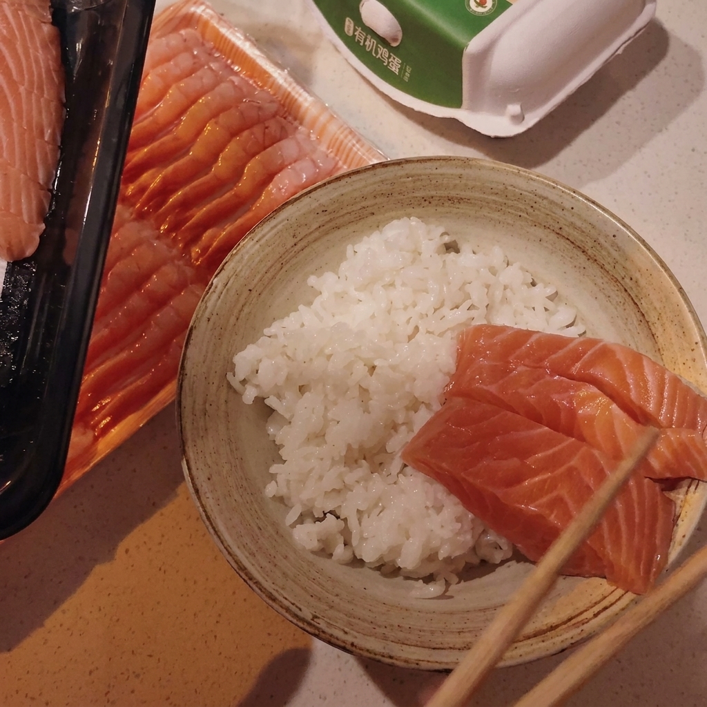 Disporre fette di salmone e capasanta cruda sopra il riso in una ciotola.