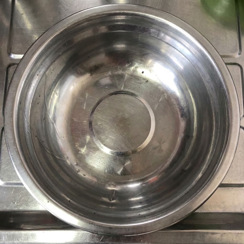 Un primo piano di salsa al peperoncino Tianjin versata in una ciotola di miscelazione in acciaio inox.