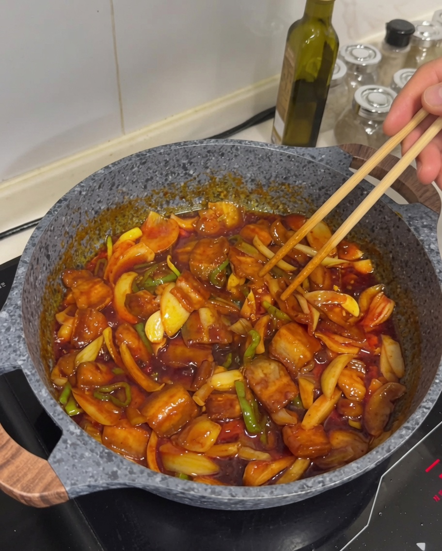 Pancetta piccante saltata in padella finita, guarnita con semi di sesamo.
