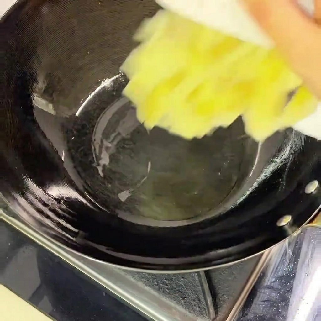Versare i crauti tritati da un piatto bianco in un wok nero riscaldato contenente un velo dolio.