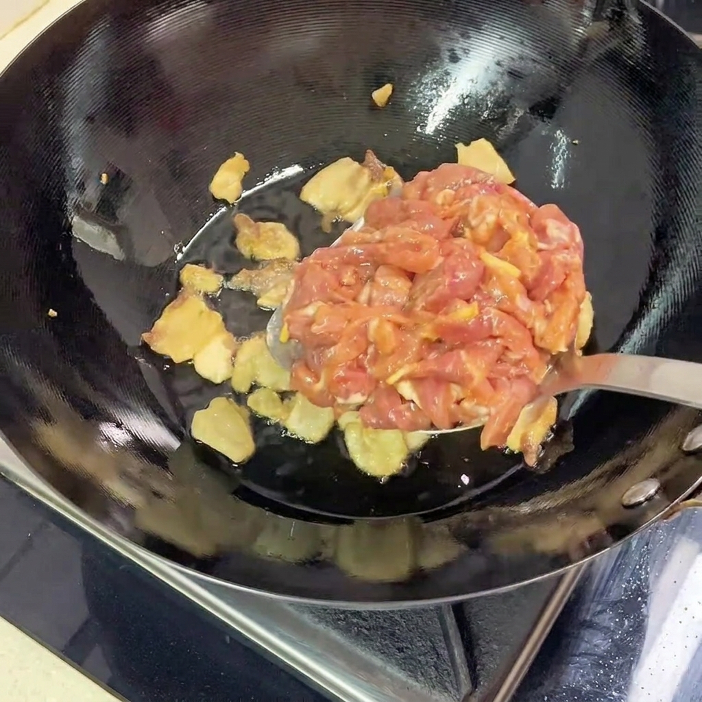 Strisce di carne di maiale magra marinata aggiunte nel wok caldo con la pancetta sciolta.