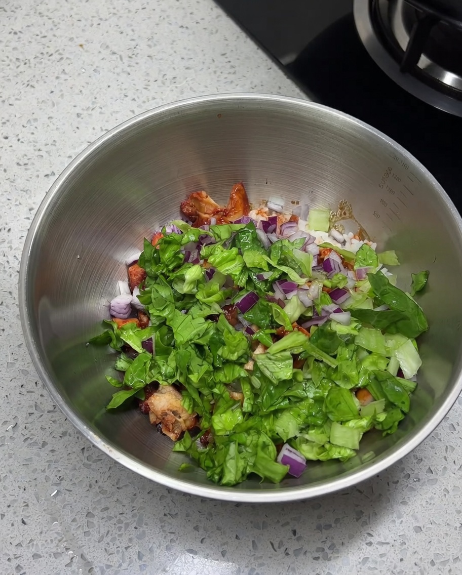 Sale, cumino e peperoncino spolverati sul composto di pollo, riso e verdure.