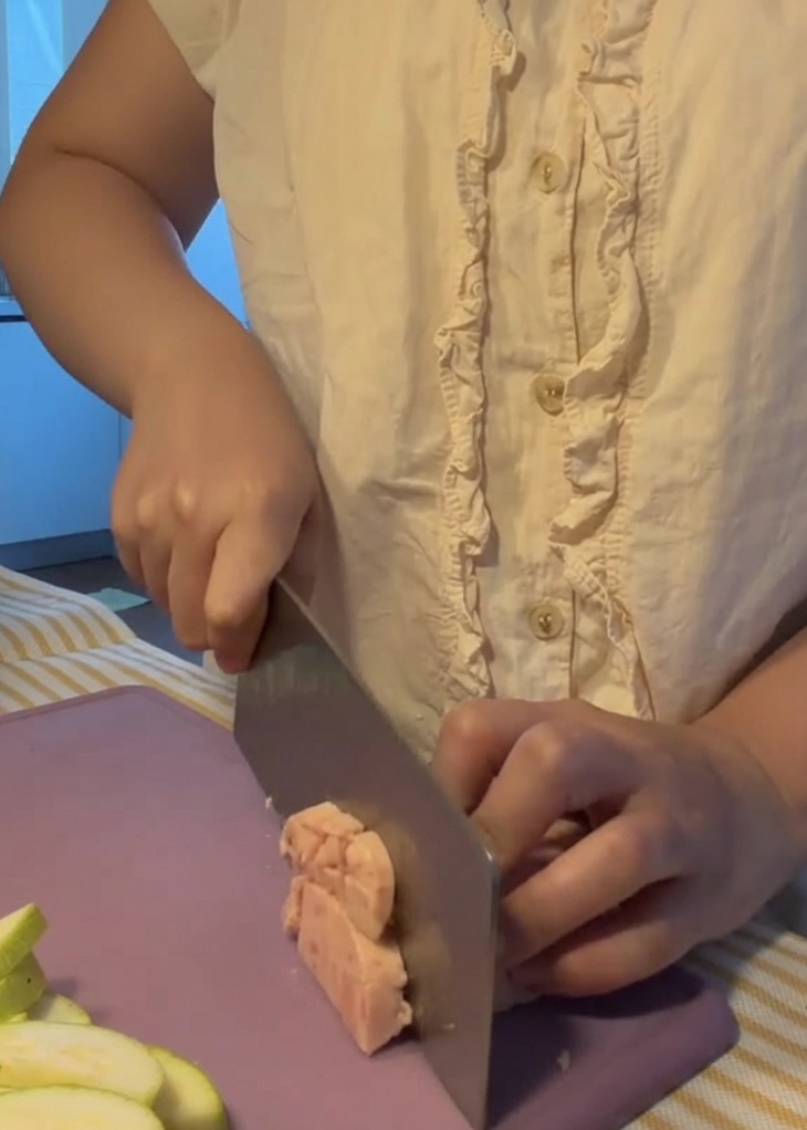 Carne in scatola tagliata a piccoli cubetti uniformi su un tagliere viola.