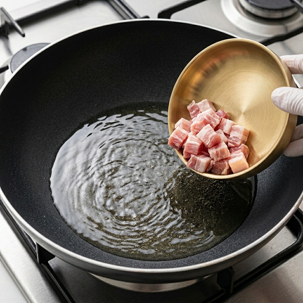 Fette sottili di pancetta di maiale che dorano in una padella calda.