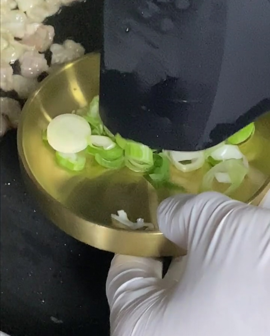 Cipollotti che cuociono in padella insieme alla pancetta.