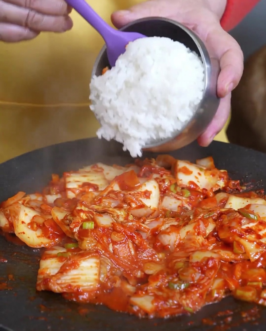 Il riso bianco cotto aggiunto nella padella sopra il kimchi saltato.
