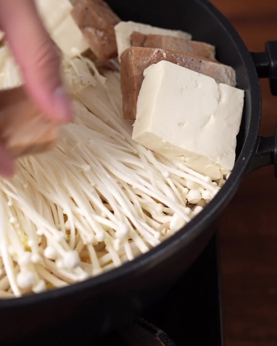 Fette di tofu e finta carne disposte a raggiera allinterno della pentola.