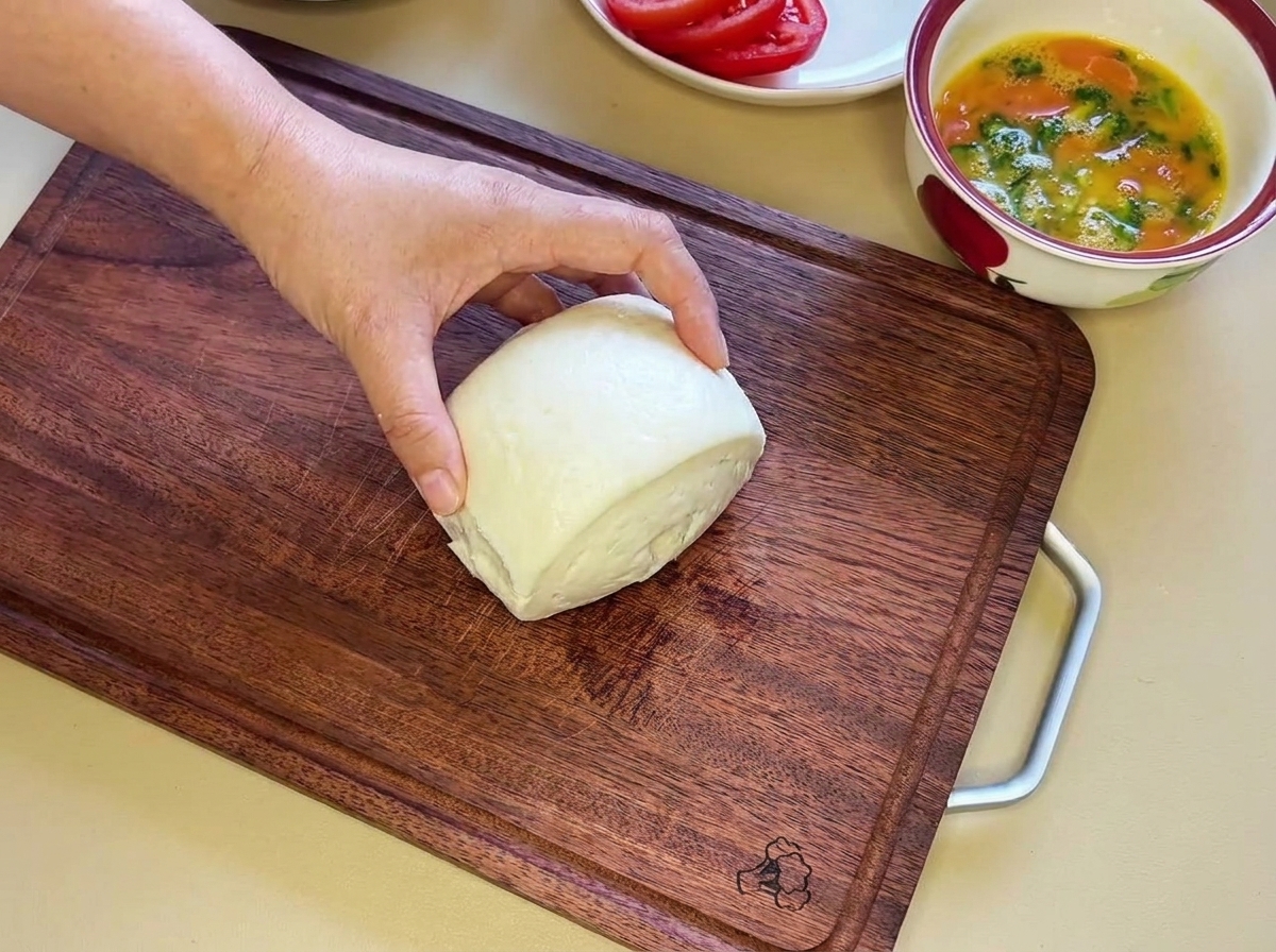 Un morbido panino bianco al vapore tagliato orizzontalmente in due metà uguali.