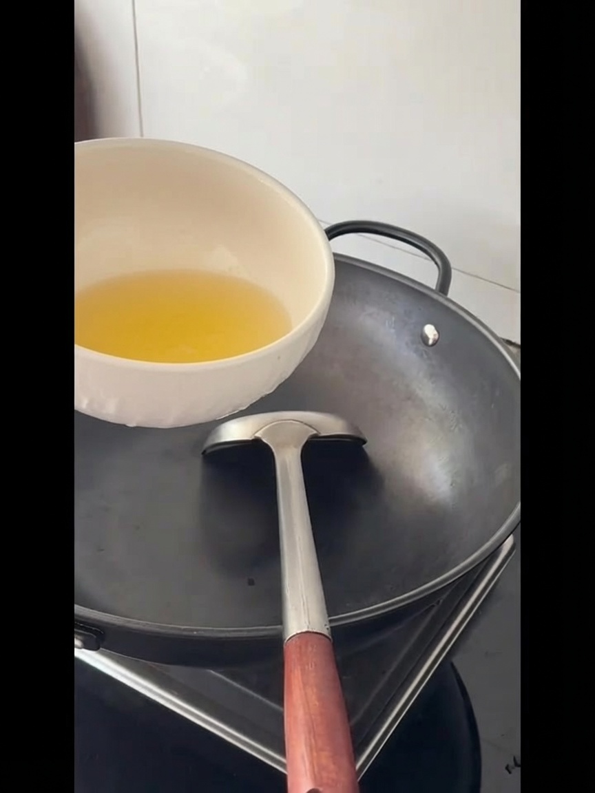 Olio di cottura versato in un grande wok vuoto.