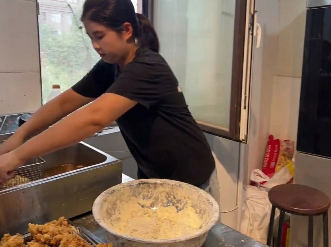 Pezzi di pollo fritto dorati e croccanti sollevati da una friggitrice.