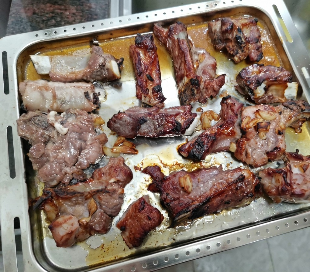 Costolette di maiale parzialmente arrostite pronte per essere spennellate con il miele.