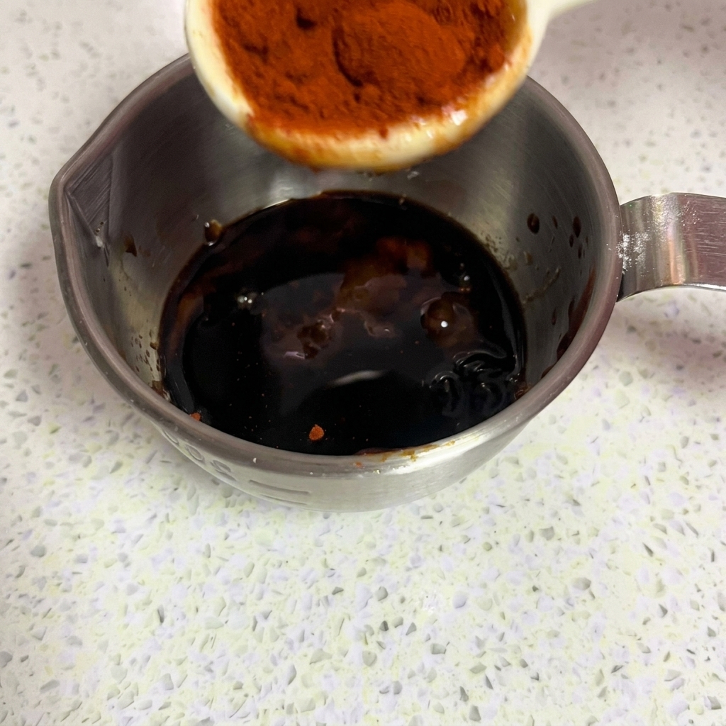 Polvere di paprika dolce di colore rosso brillante aggiunta alla marinatura.