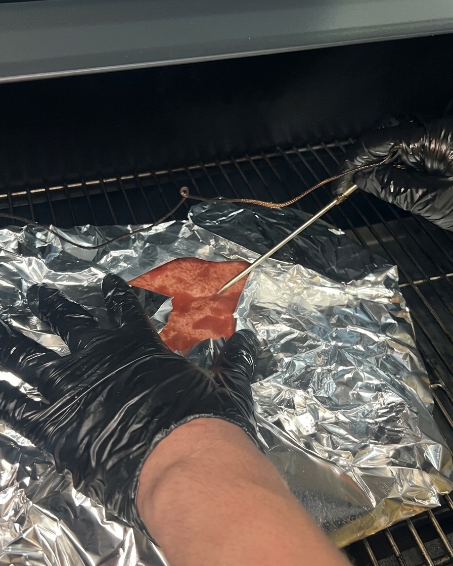 Il brisket avvolto riposto nellaffumicatore con la sonda del termometro reinserita.