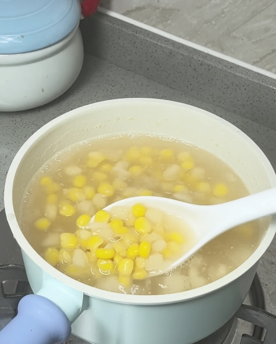 Latte di cocco versato a filo sulla zuppa di mais e castagne dacqua pronta.