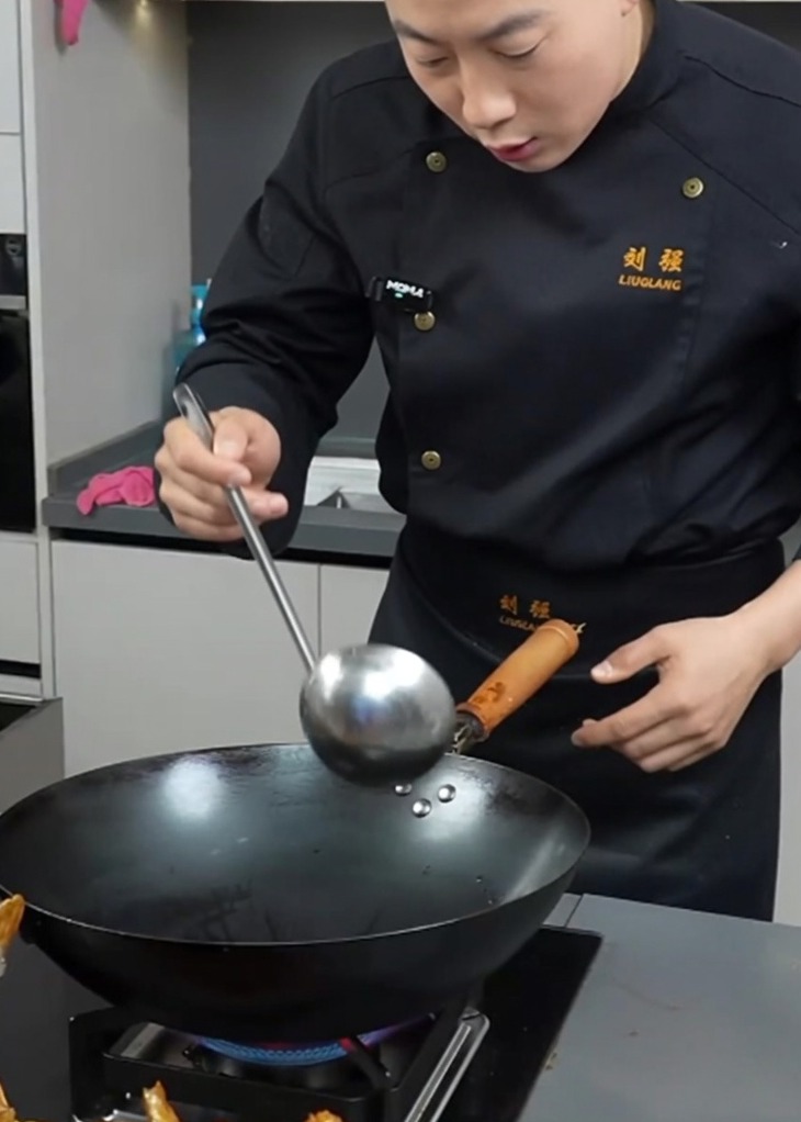 Un wok caldo con strutto fuso e olio da cucina sfrigolante, pronto per gli ingredienti.