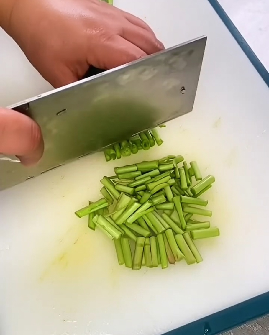 Erba cipollina cinese fresca appena tritata su un tagliere.
