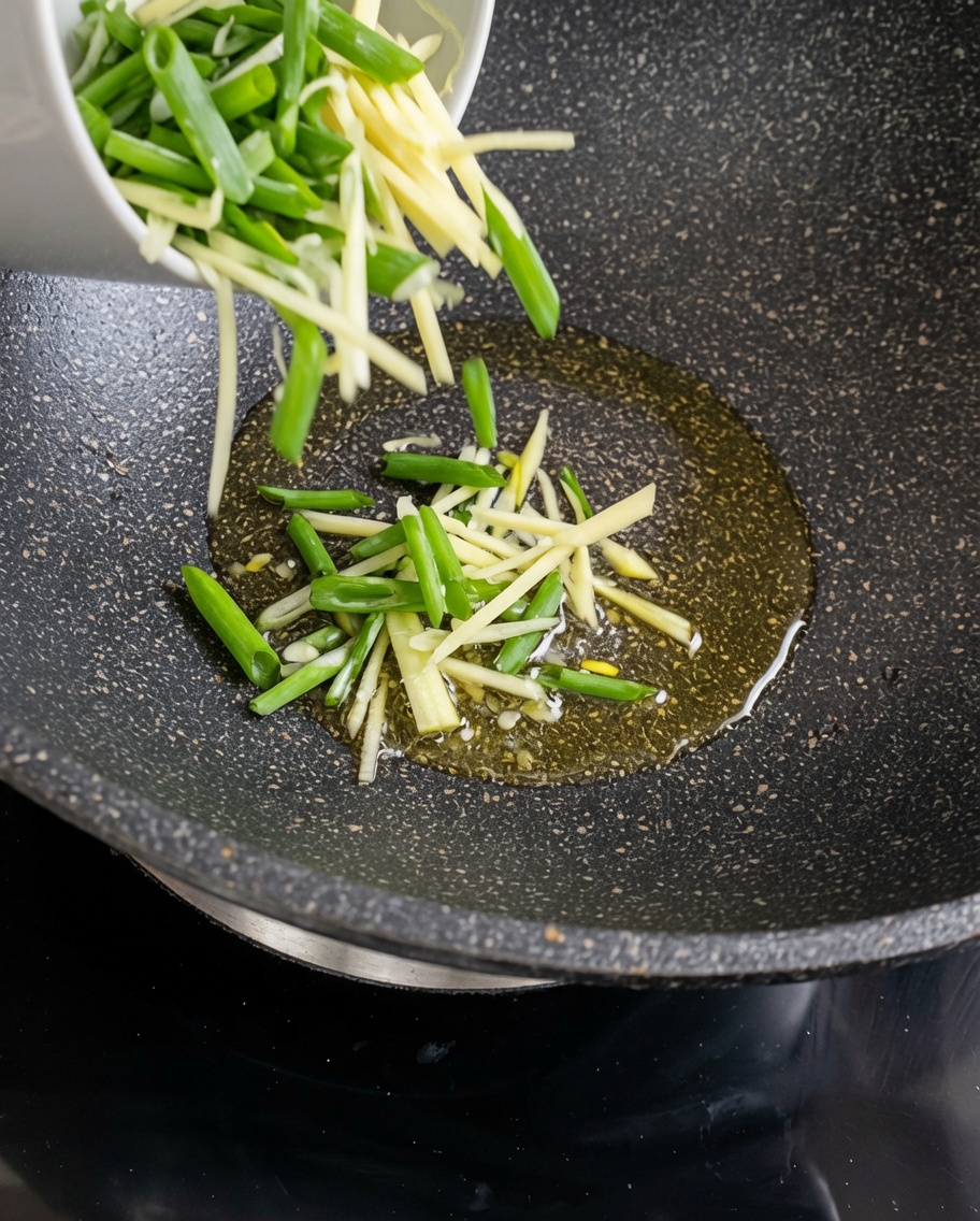 Listarelle di patate crude saltate in un wok caldo e oliato.