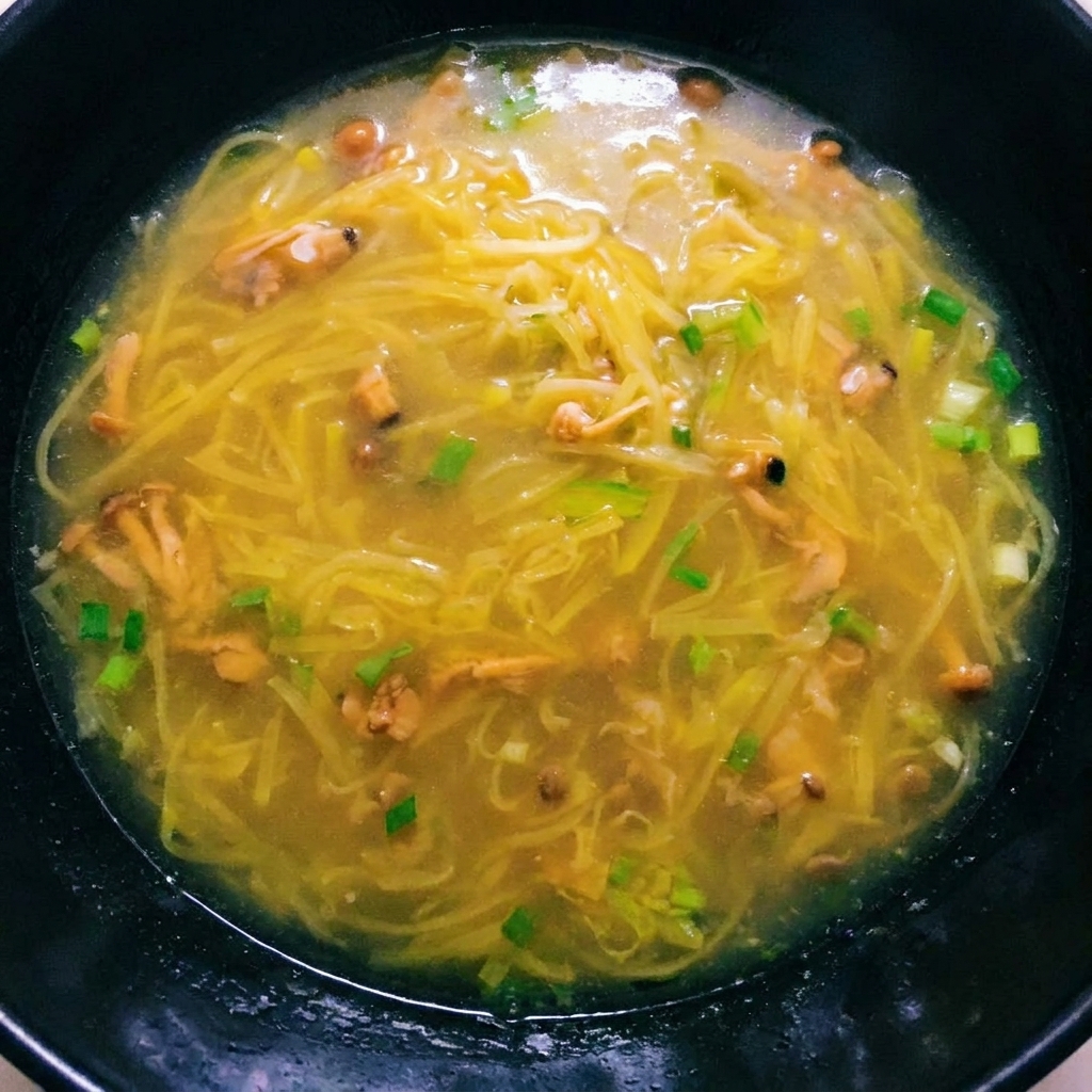 Una ricca zuppa di patate in ebollizione con polpa di vongole aggiunta, pronta per il condimento finale.