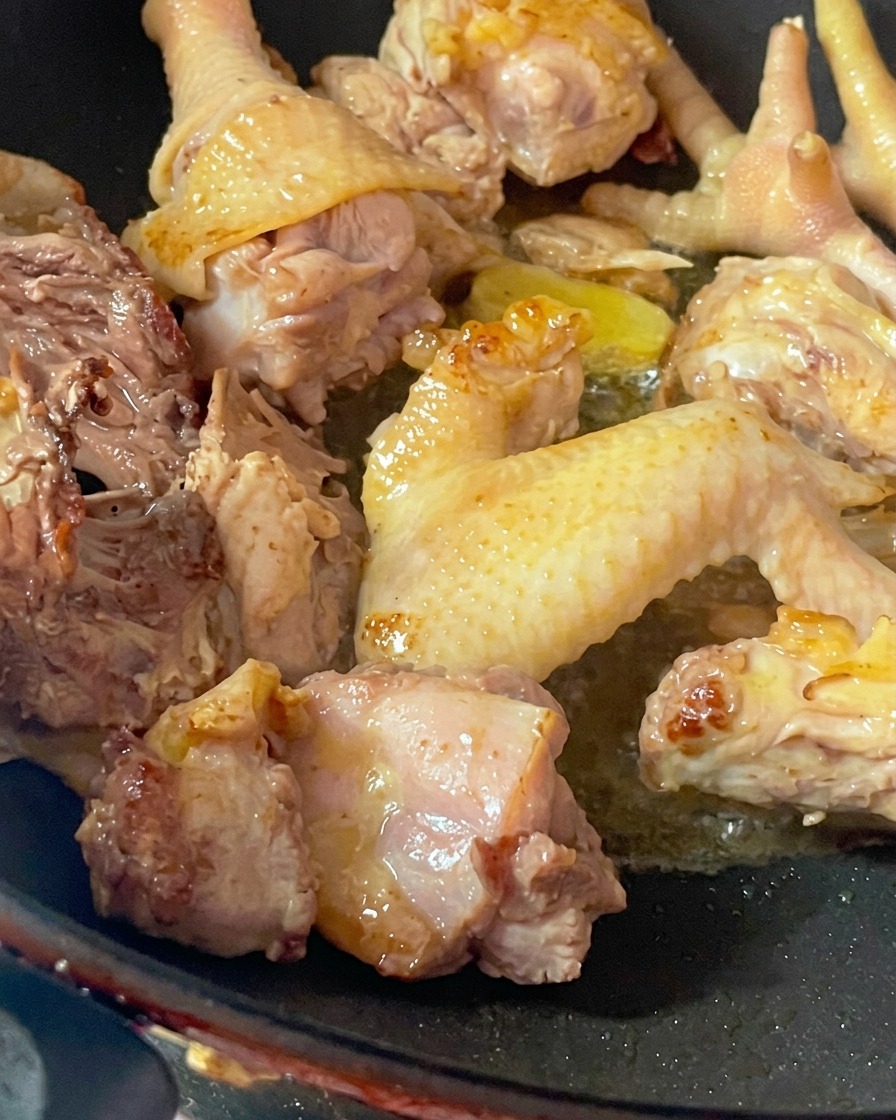 Pezzi crudi di gallina vecchia fatti saltare in un wok caldo per rimuovere lumidità.