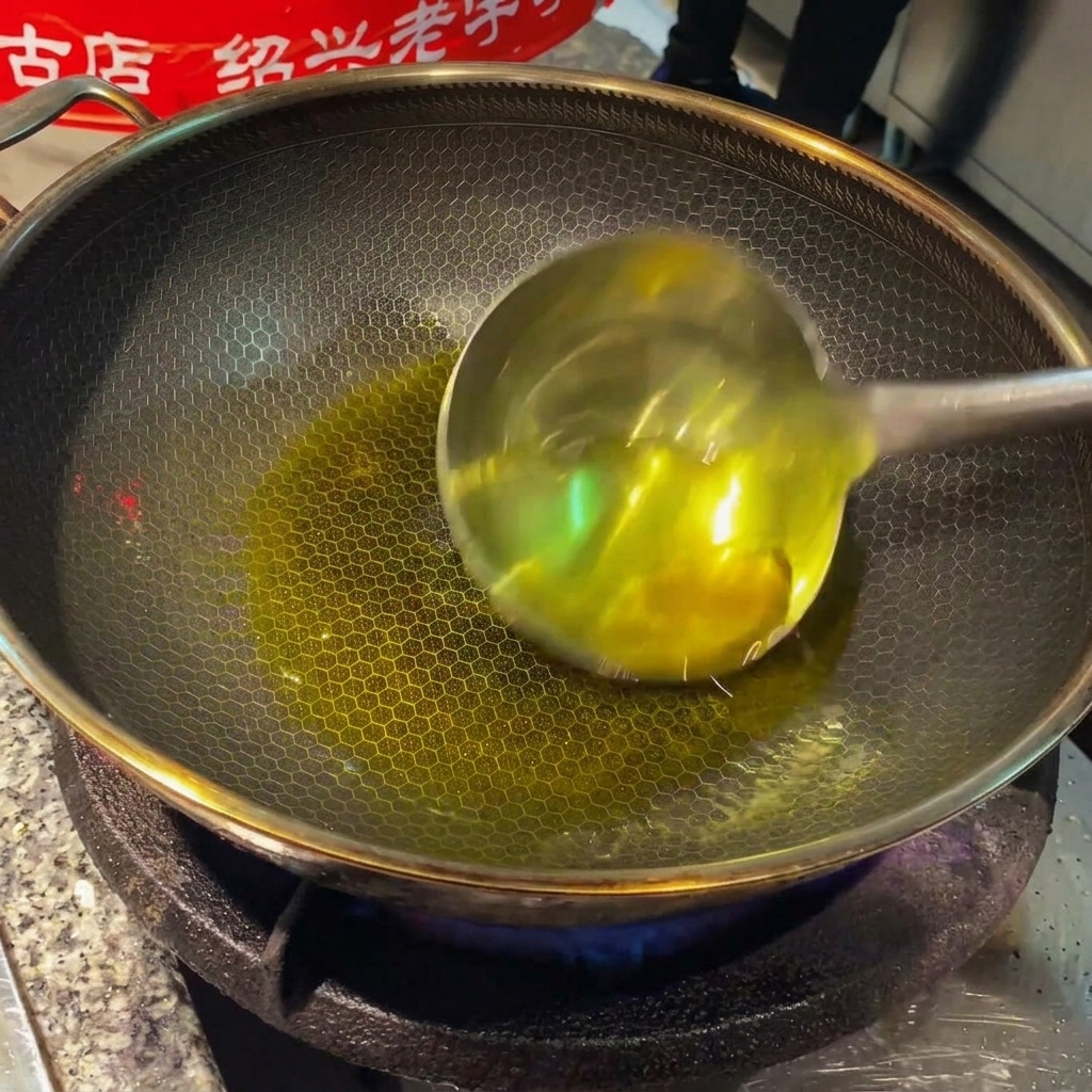 Fette di zenzero e spicchi daglio che sfrigolano nellolio caldo allinterno di un wok.
