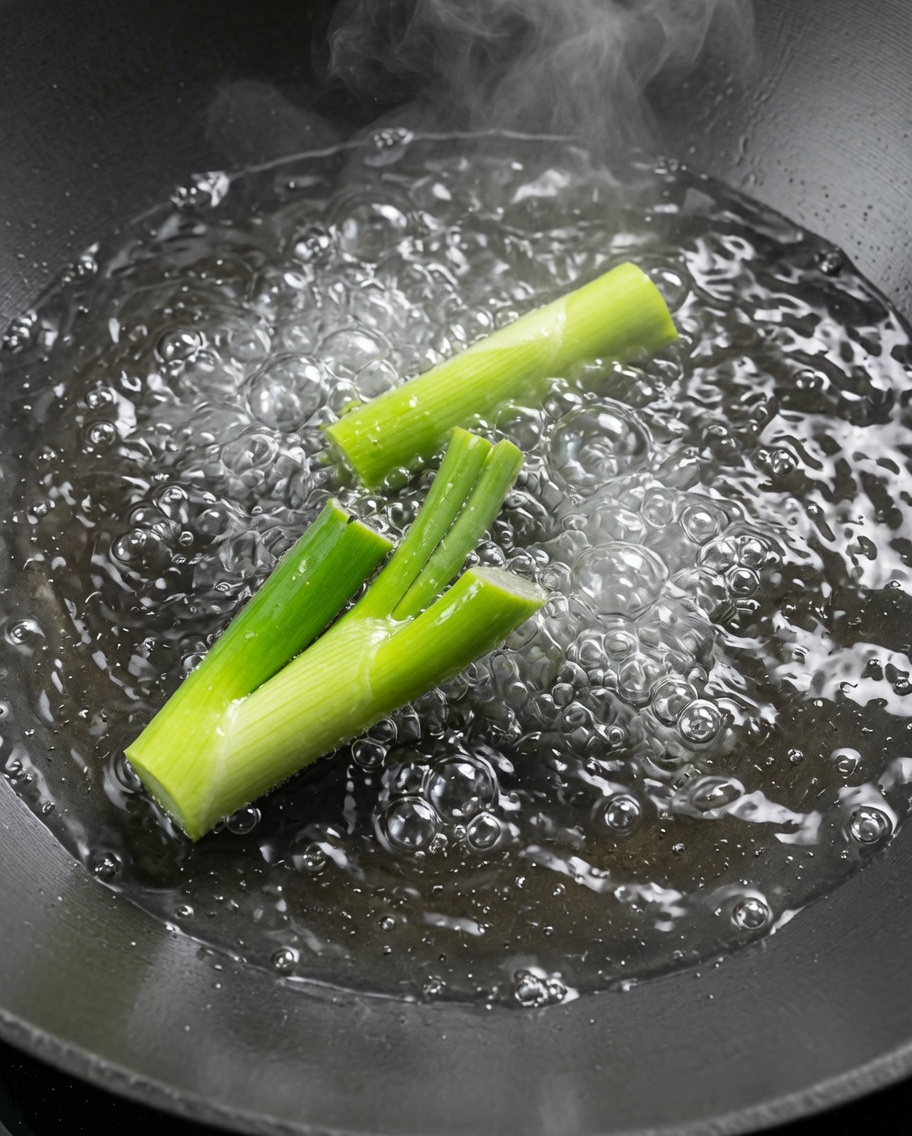 Gamberi sbollentati in un wok con acqua bollente e cipollotti.