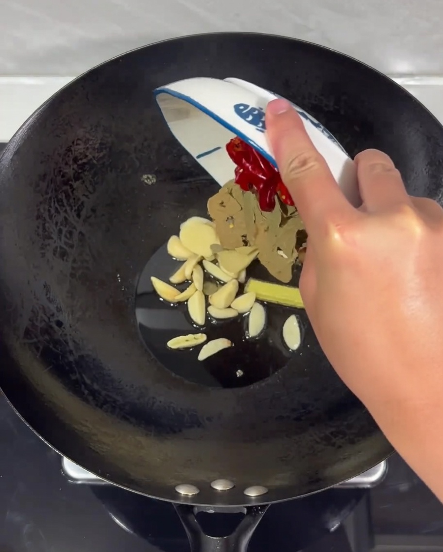 Un mix di zenzero, aglio e peperoncini secchi che sfrigola nellolio caldo in un wok.