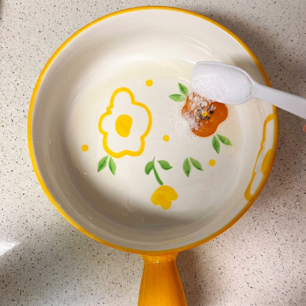 Una ciotolina contenente una miscela di salse di soia, zucchero, sale, amido di mais e acqua, mescolata con un cucchiaio.