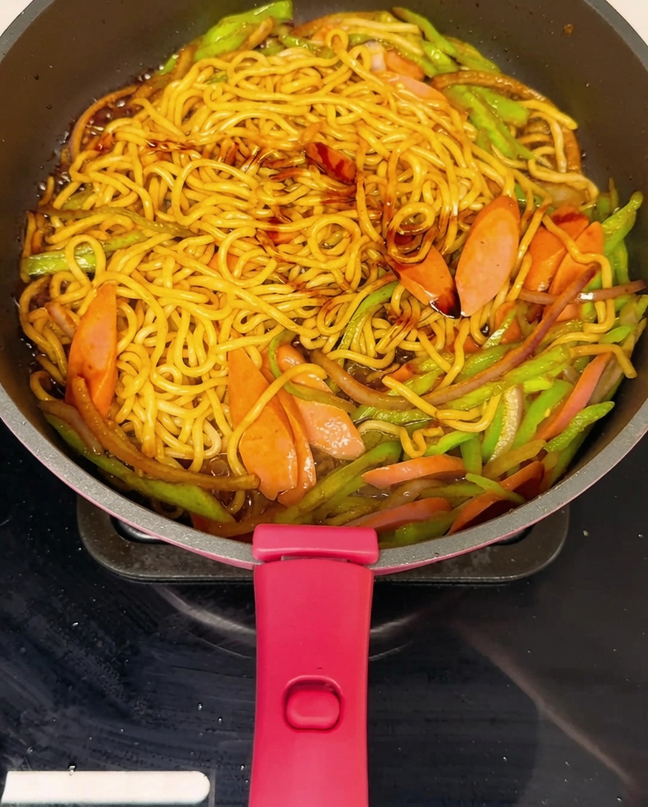 Noodles saltati in padella conditi con pepe nero macinato fresco.