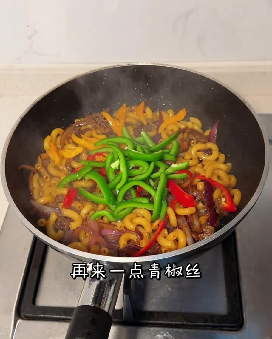 Peperone verde a fette mescolato nel mix di manzo e maccheroni.