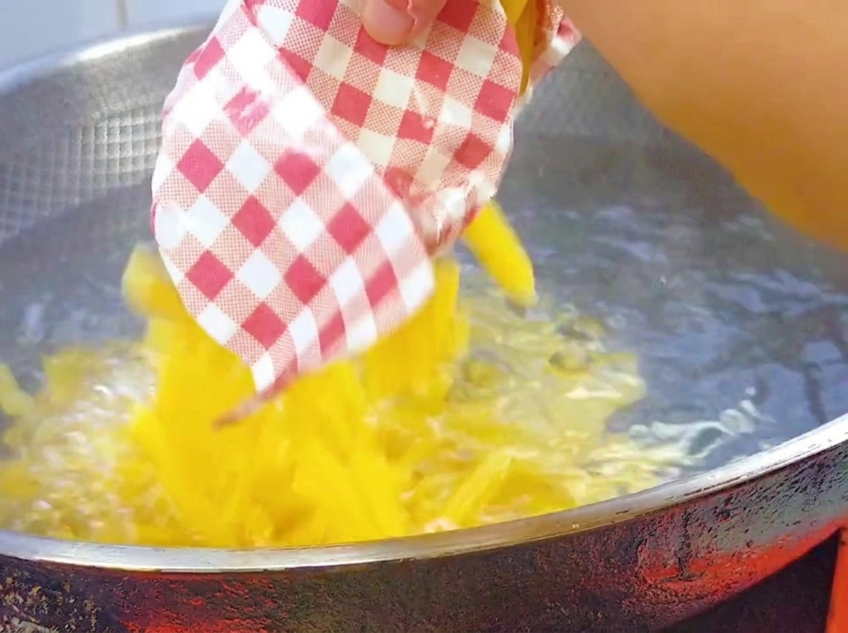 Penne secche versate in un wok grande con acqua bollente salata.