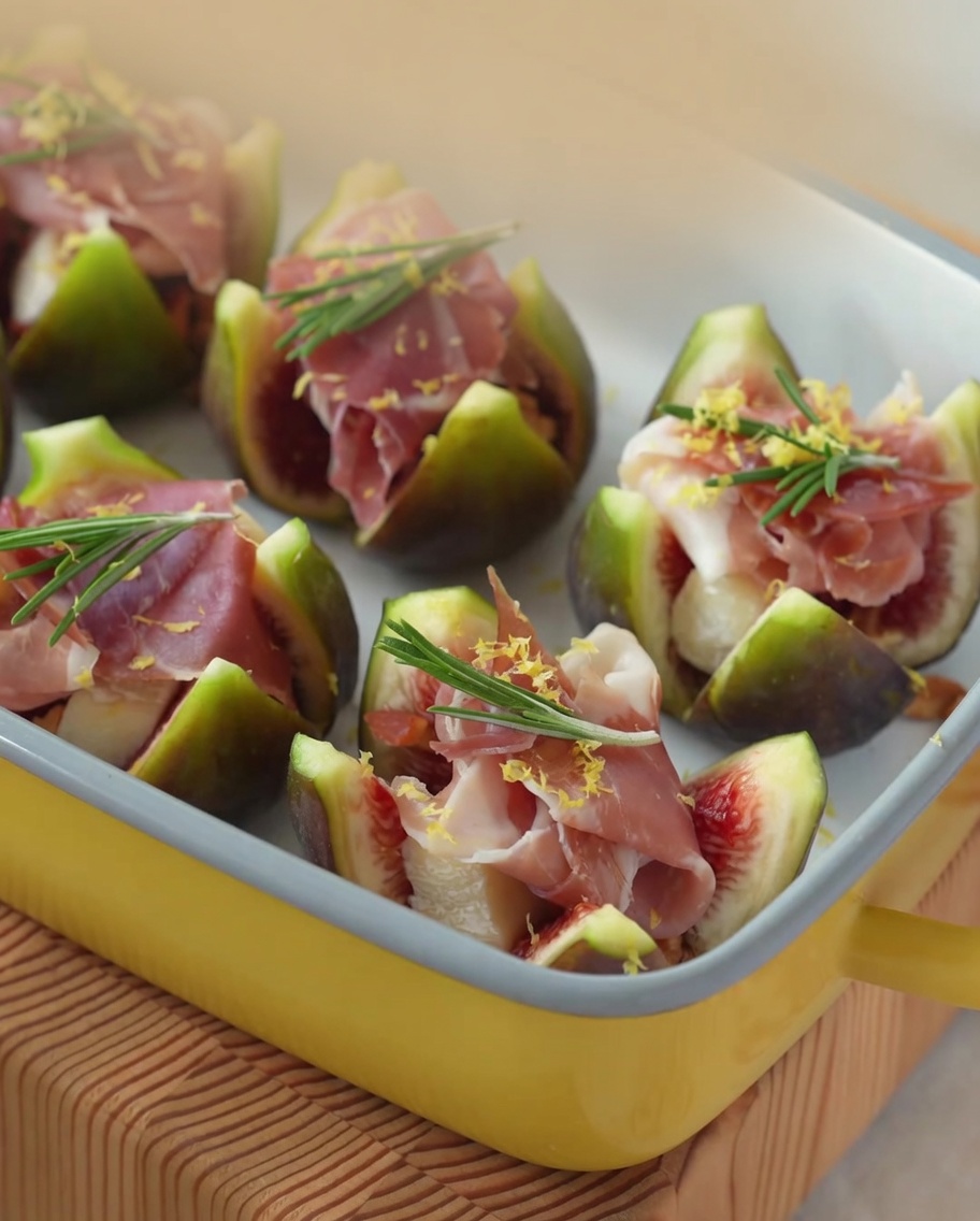 Primo piano del miele fatto colare sui fichi ripieni di Brie e prosciutto.