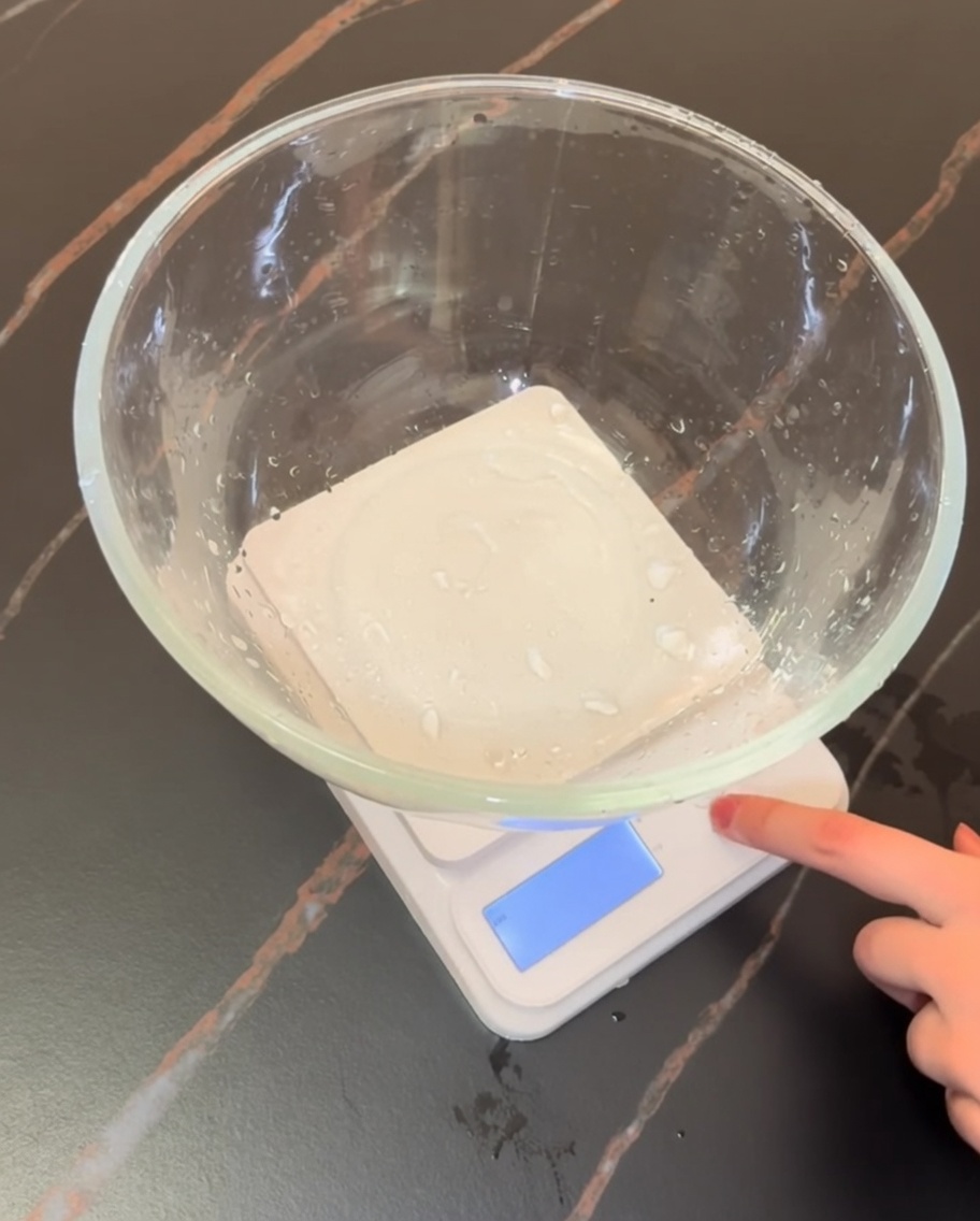 Una bilancia da cucina digitale con una ciotola di vetro contenente farina e ingredienti secchi.