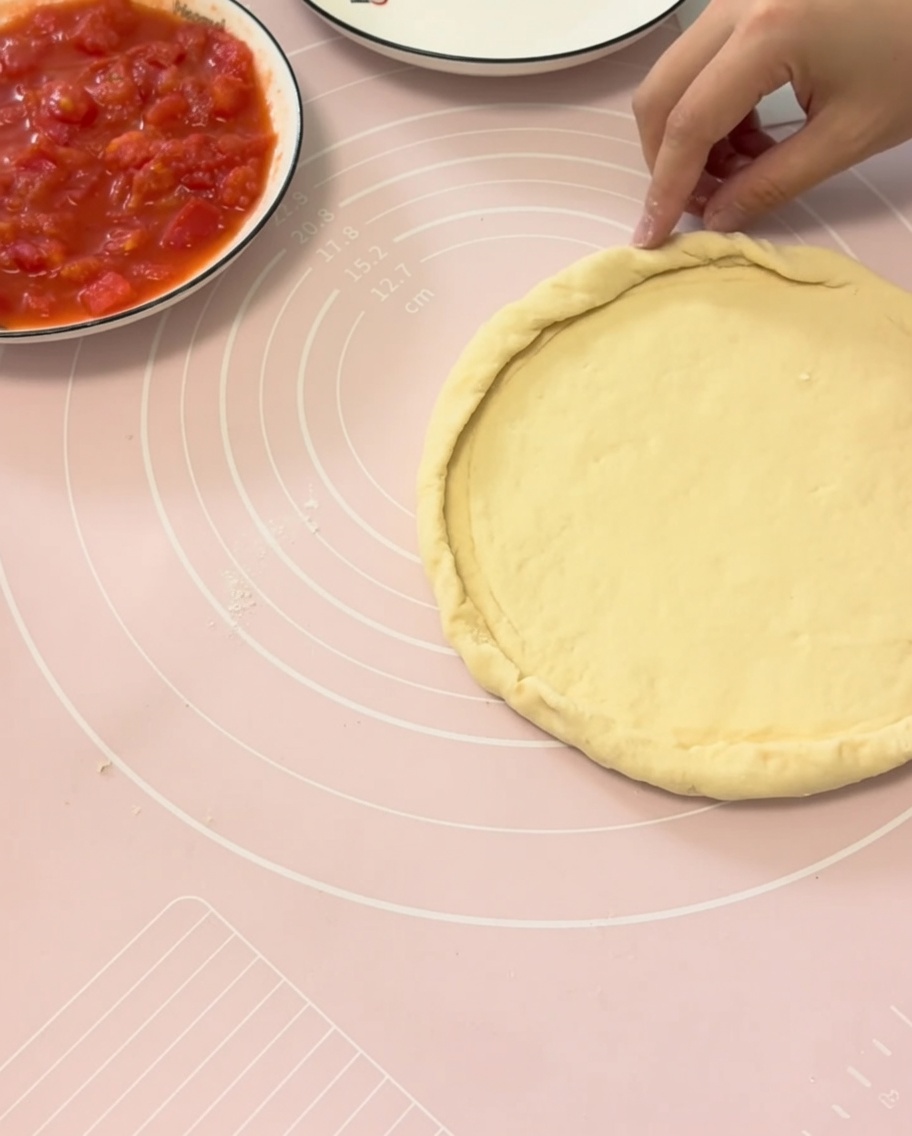 Mani che piegano i bordi dellimpasto sopra un piatto per formare una crosta perfetta.