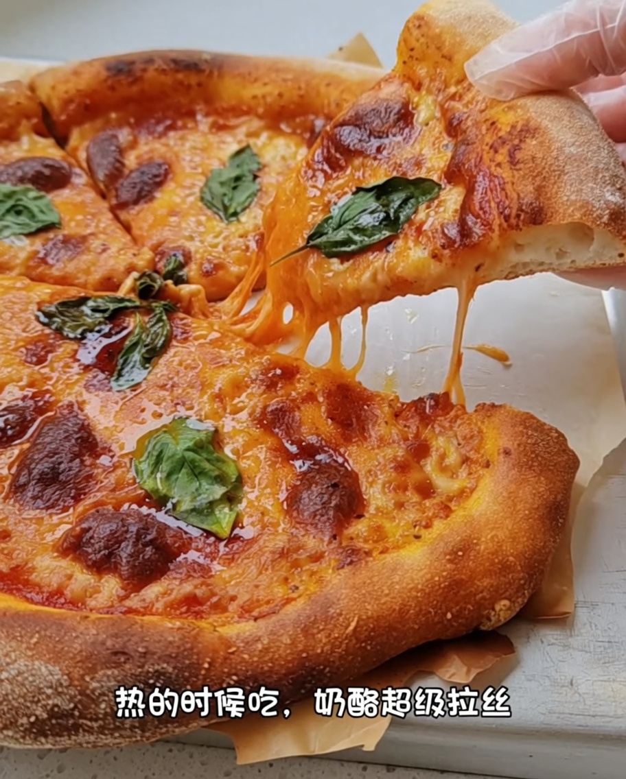 Mani che usano le nocche per stendere un disco di pizza su una superficie infarinata.